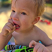 Erik is registered to the contest to win money with this photo: toddler, child, wet_hair, fingers, towel, colorful, outdoor, sunlight, closeup, portrait, skin, hand, face, expression, curious, young_child, summer, daylight, playful, bare_shoulders