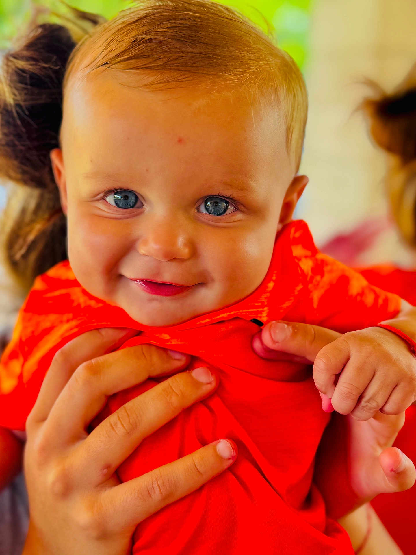 ézio a rejoint le concours — aidez-le/la à gagner de superbes lots ! baby, child, smile, blue_eyes, orange_shirt, hands, portrait, close_up, cute, infant, person, skin, face, expression, holding, bright_colors, happy, young_child, human, background_blur