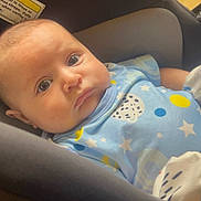 Asher is registered to the contest to win money with this photo: baby, infant, car_seat, blue_outfit, mittens, blanket, stars_pattern, indoor, close_up, face, head, person, child, newborn, cute, soft_lighting, comfort, seat, clothing, portrait