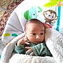 Rene is registered to the contest to win money with this photo: baby, blanket, baby_seat, elephant_cartoon, monkey_cartoon, infant, curious, cozy, soft_texture, indoor, child, cute, wrapped, hand_gesture, colorful, patterned, young, portrait, warm, resting