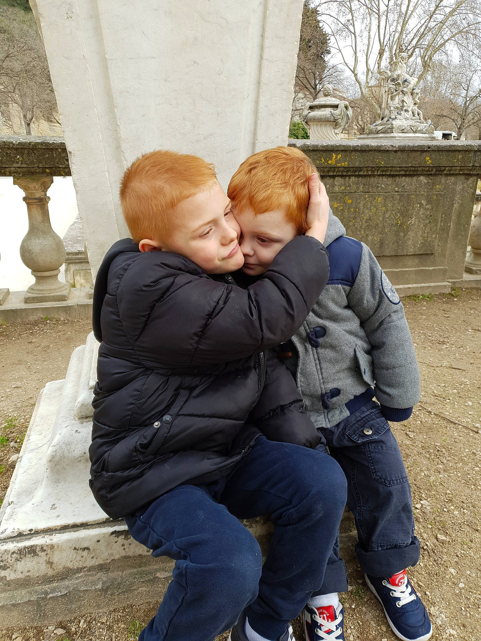 Lucas participe au concours pour gagner de l'argent avec cette photo : child, hug, interaction, joy, person, sitting, toddler