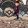 child, boy, graffiti, mural, owl, rocky_ground, urban, street_art, casual_clothing, outdoor, portrait, young, colorful, wall, expression, curious, standing, nature, rocks, art