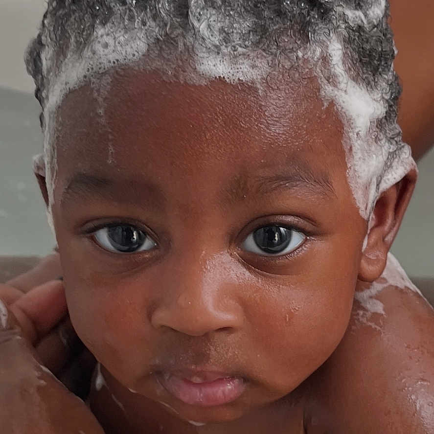 Arys is registered to the contest to win money with this photo: adult_hand, baby, bath, child, closeup, curly_hair, cute, expression, eyes, face, foam, hand, indoors, infant, personal_care, portrait, shampoo, skin, water, wet