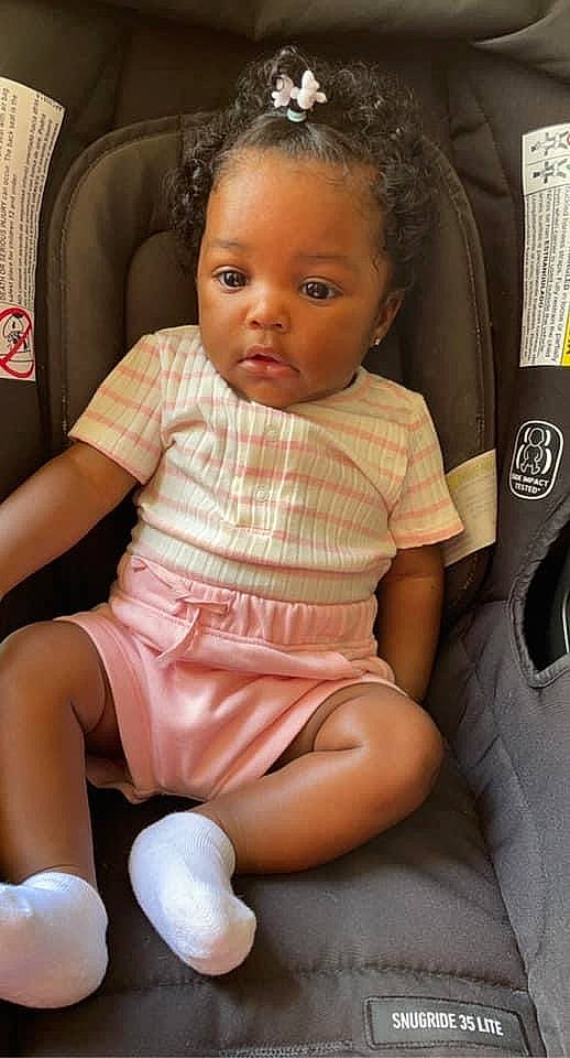 Kailee is registered to the contest to win money with this photo: baby, baby_toddler_clothing, chair, cheek, comfort, eye, face, finger, fun, hairstyle, head, knee, lap, leg, mouth, person, skin, stomach, thigh, toddler