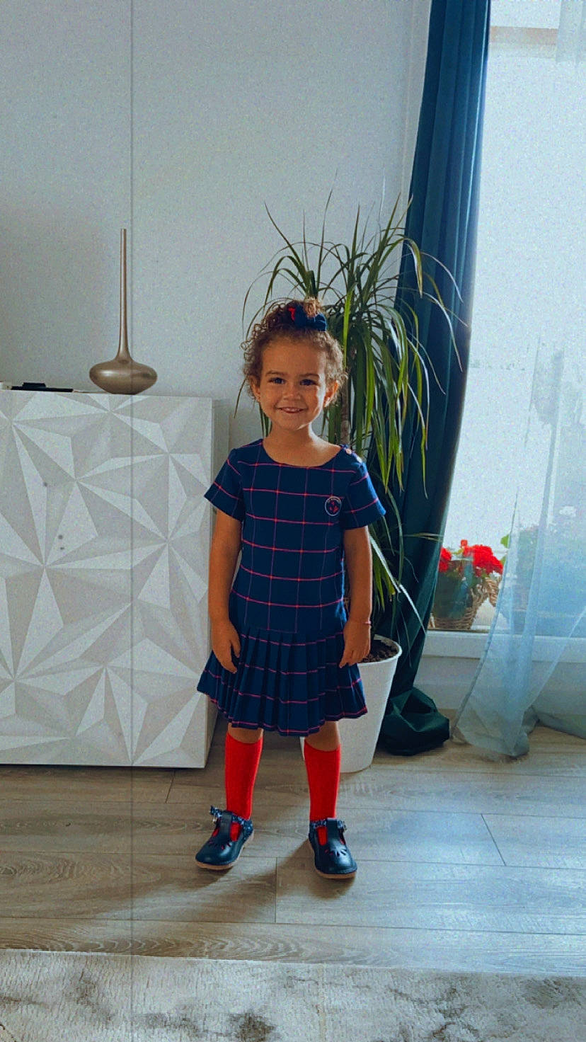 Talia participe au concours pour gagner de l'argent avec cette photo : child, dress, electric_blue, face, fashion_design, flooring, flower, flowerpot, hair, houseplant, joy, knee, pattern, person, plant, room, sleeve, t_shirt, toddler, visual_arts