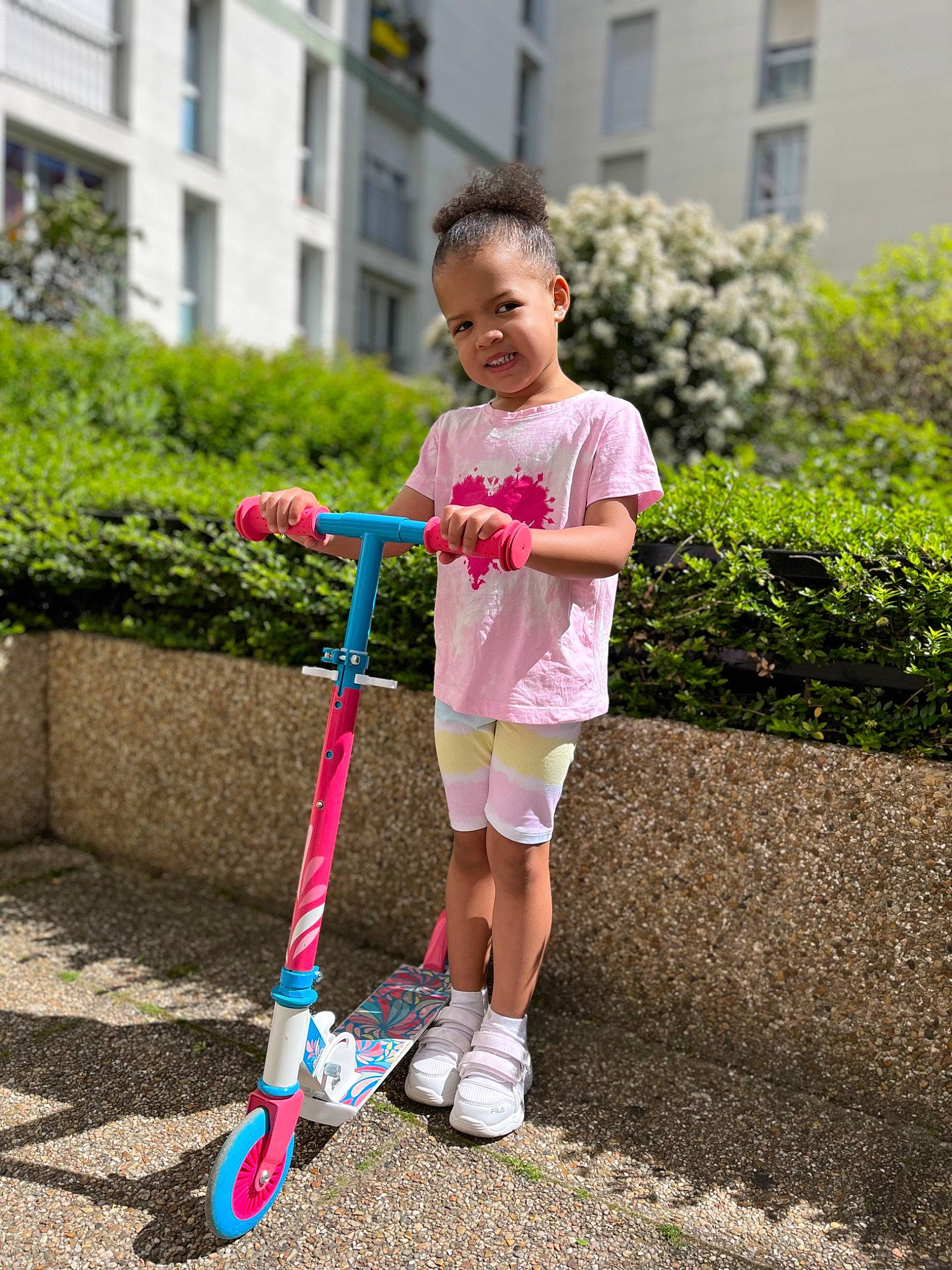 Siana participe au concours pour gagner de l'argent avec cette photo : asphalt, building, footwear, fun, grass, happy, joy, kick_scooter, lawn, leisure, people_in_nature, person, plant, recreation, shorts, smile, sneakers, t_shirt, tire, toddler