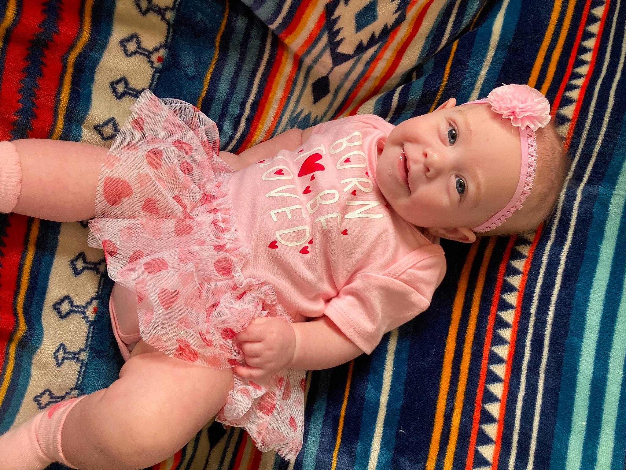 Margaret is registered to the contest to win money with this photo: arm, baby, baby_toddler_clothing, cheek, dress, eye, finger, hand, happy, headwear, human_body, iris, lip, mouth, nose, pattern, person, pink, skin, sleeve