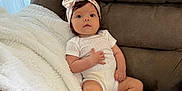 Valentina joined the competition — help win amazing prizes! baby, infant, headband, blanket, couch, brown_couch, white_blanket, baby_clothing, indoors, child, face, person, cute, relaxed, sitting, young_child, soft_texture, cozy, portrait, looking
