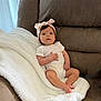 Valentina joined the competition — help win amazing prizes! baby, infant, headband, blanket, couch, brown_couch, white_blanket, baby_clothing, indoors, child, face, person, cute, relaxed, sitting, young_child, soft_texture, cozy, portrait, looking