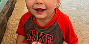 Grayson joined the competition — help win amazing prizes! baseball, carpet, casual, child, clothing, face, furniture, happy, home, indoor, light, nike, person, red_shirt, shorts, sitting, smiling, toddler, toy, young_child