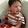 Jett is registered to the contest to win money with this photo: baby, infant, child, striped_shirt, brown_hair, blue_eyes, cushion, indoor, cute, portrait, hand, clothing, seated, person, young_child, comfortable, curious, skin, expression, fabric