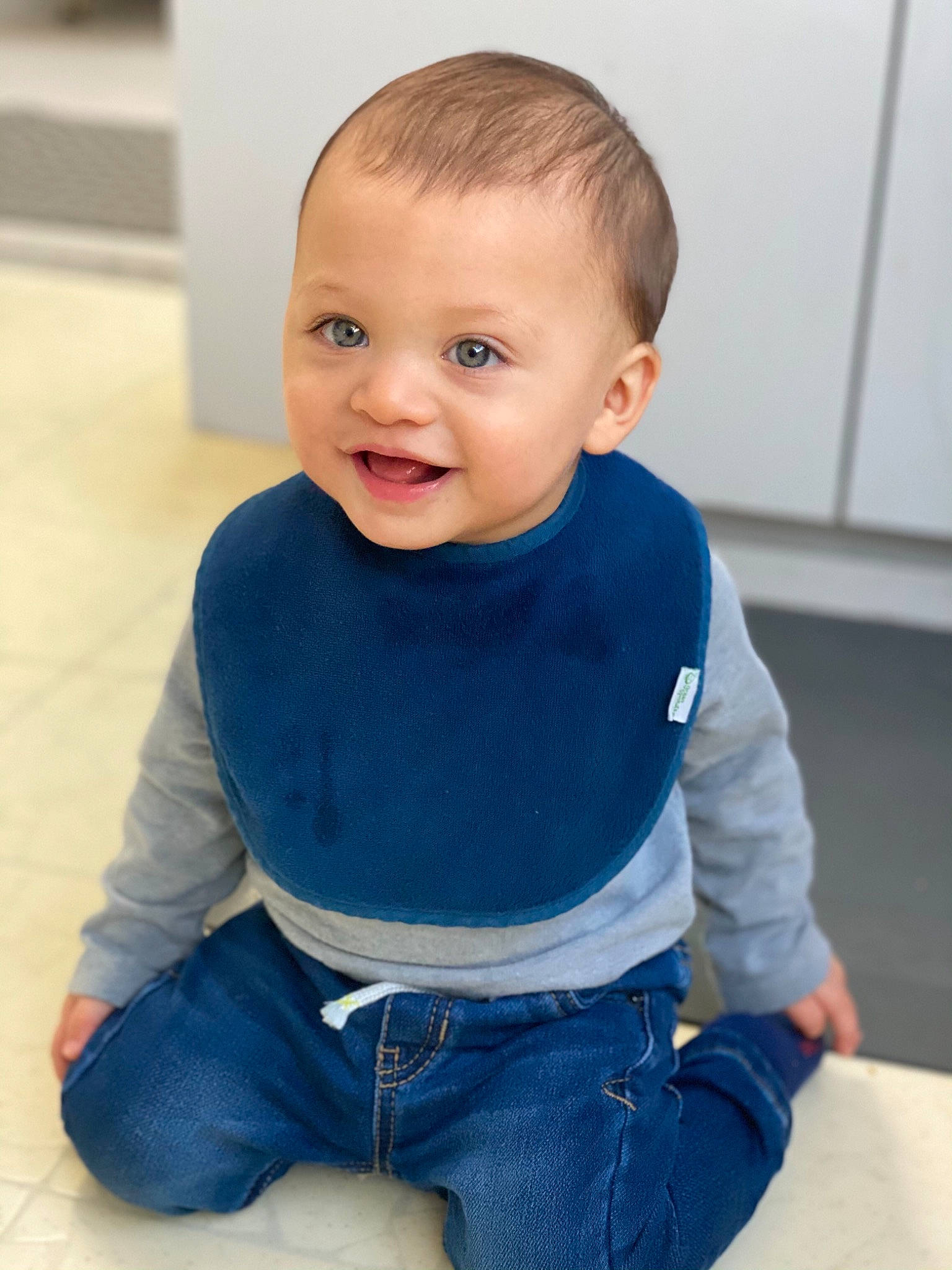 Kaeden is registered to the contest to win money with this photo: arm, baby_toddler_clothing, cheek, clothing, floor, flooring, hair, happy, iris, jeans, joint, neck, nose, organ, person, skin, sleeve, smile, standing, t_shirt