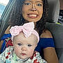 woman, baby, car, headband, curly_hair, facial_piercing, blue_shirt, spongebob, seat, seatbelt, expression, cute, child, person, indoor, portrait, holding, funny_face, clothing, accessory