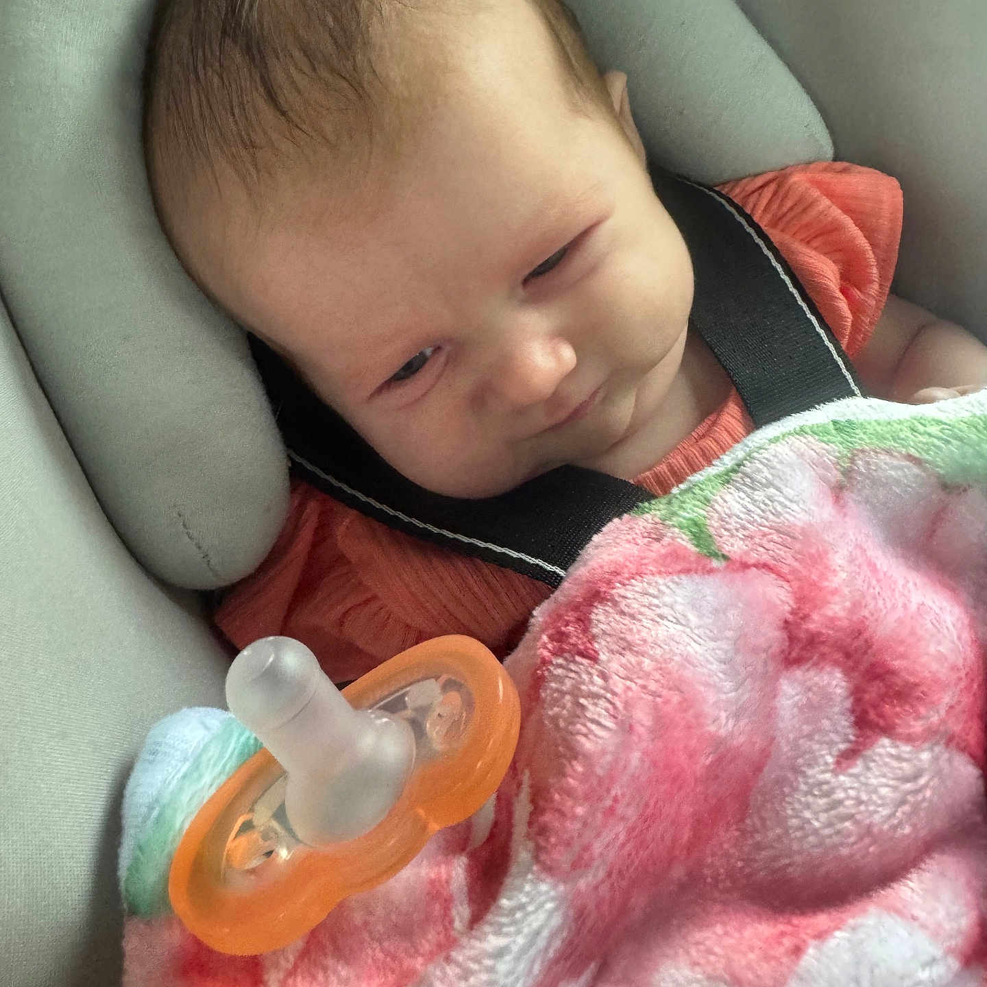 Victoria joined the competition — help win amazing prizes! baby, blanket, pacifier, car_seat, child, infant, face, clothing, pink, orange, soft_toy, comfort, resting, cute, young_child, indoor, portrait, expression, seatbelt, head_support