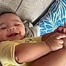 baby, child, close_up, couch, cushion, family_photo, hands, happy, home, indoor, infant, legs, lying_down, patterned_pillow, portrait, relaxed, sitting, smiling, sofa, yellow_clothing