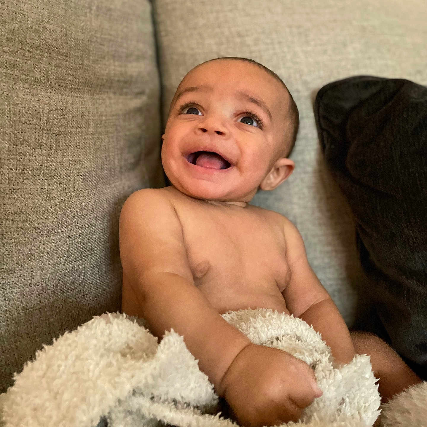 Theo is registered to the contest to win money with this photo: baby, babylaughing, blanket, clothing, cushion, face, happy, head, homedecor, hosiery, laughing, newborn, person, photography, portrait, quilt, smile, sock, towel