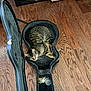 cat, tabby_cat, guitar_case, wooden_floor, indoor, board_games, shelf, open_case, pet, feline, curious, relaxed, cozy, plush_lining, flooring, storage, casual, home, animal, resting