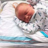 newborn, baby, sleeping, infant, face, portrait, pacifier, swaddled, blanket, hospital, bedding, onesie, clothing, vehicle_pattern, peaceful, resting, indoors, close_up, head, child