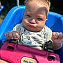 Liam is registered to the contest to win money with this photo: baby, child, swing, playground, outdoor, sunlight, curly_hair, pout, blue, pink, plastic, seat, bib, expression, hands, safety_strap, face, cute, funny_face, summer