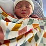 baby, bed, blanket, child, closeup, colorful, cozy, cute, geometric_pattern, hat, indoors, infant, newborn, peaceful, person, puckered_lips, resting, sleeping, soft, warm