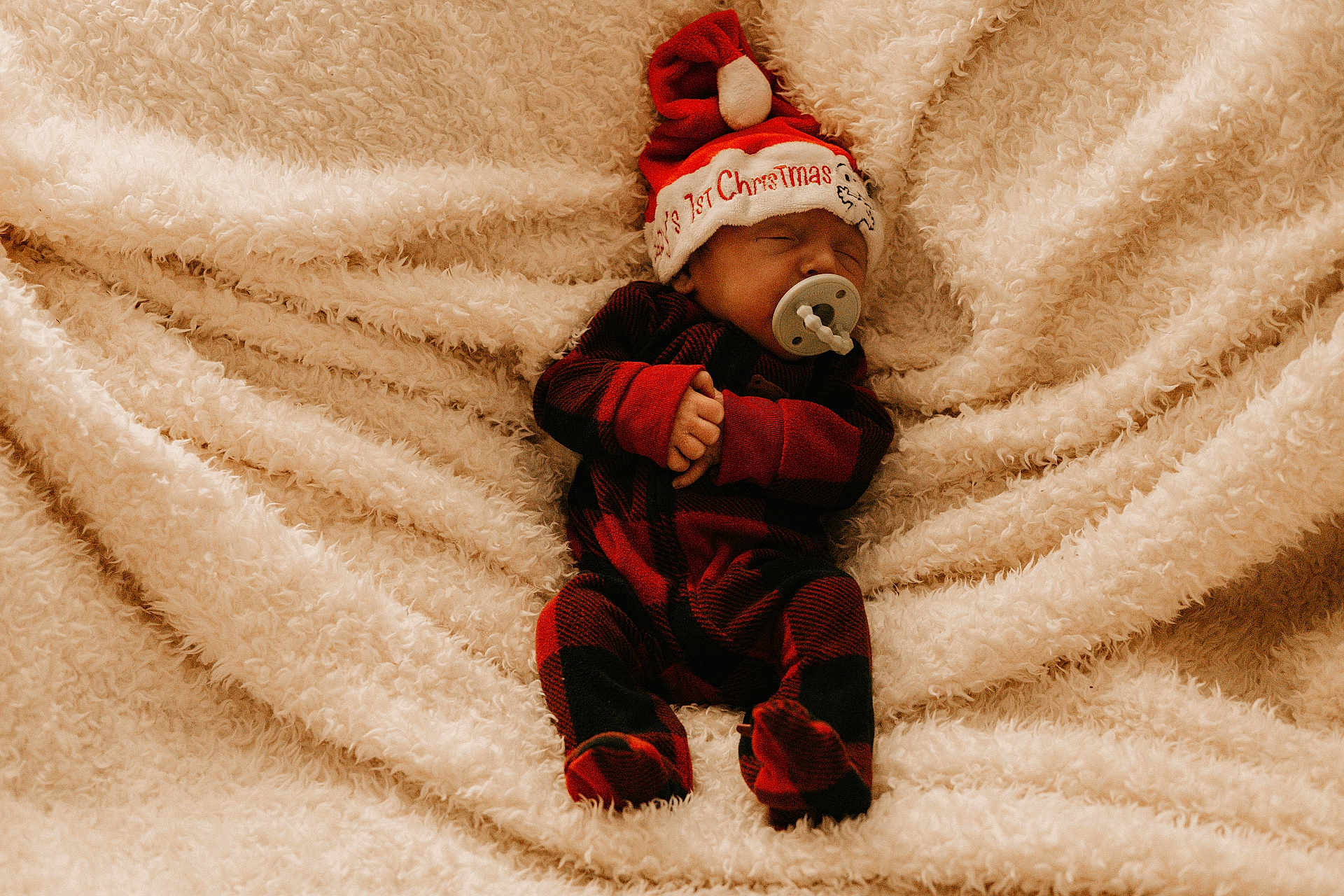 Malachi joined the competition — help win amazing prizes! baby, newborn, sleeping, pacifier, christmas_hat, red_and_black_pajamas, plaid, blanket, soft_texture, cozy, holiday, infant, cute, peaceful, child, indoors, portrait, festive, sleep, warm