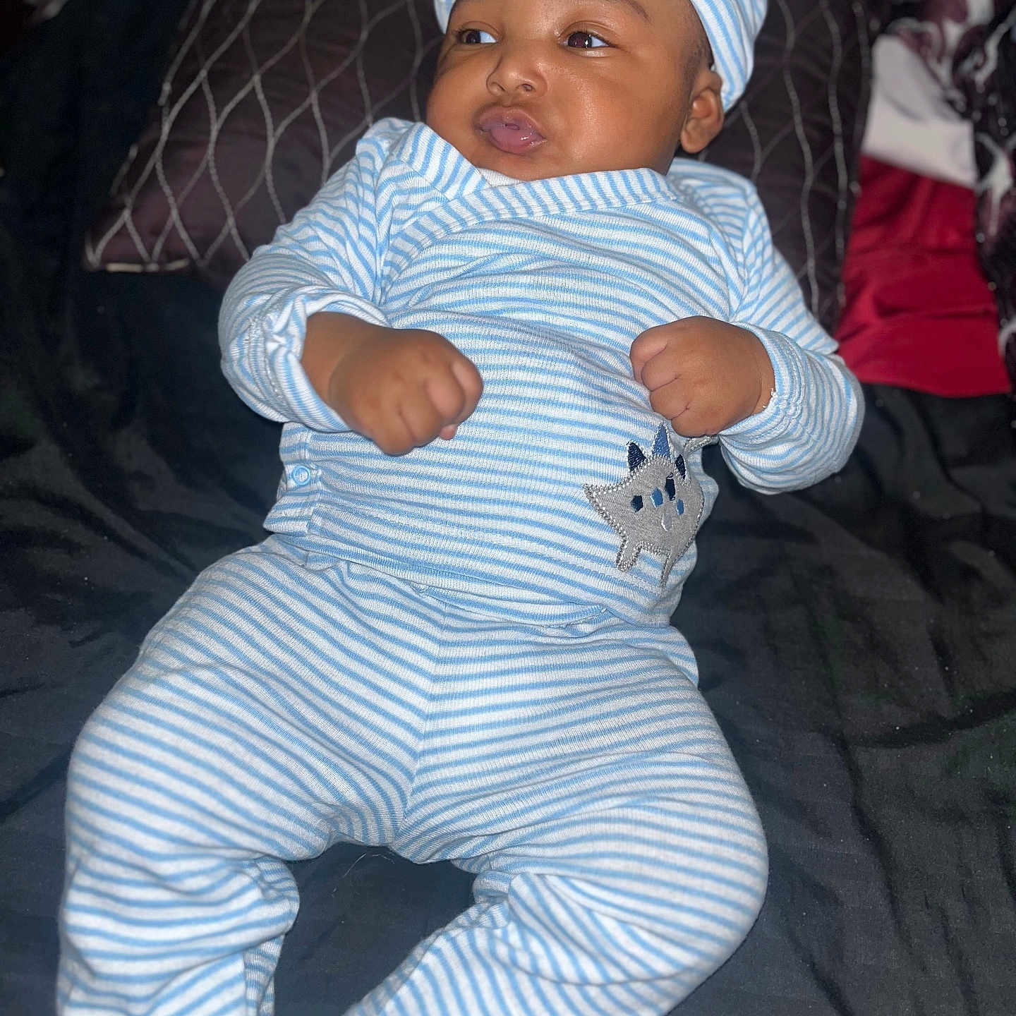 Elijah is registered to the contest to win money with this photo: baby, bed, blanket, child, cozy, cute, expression, face, footed_pajamas, hands, hat, indoors, infant, pajamas, pillow, portrait, relaxed, skin, sleepwear, striped_clothing