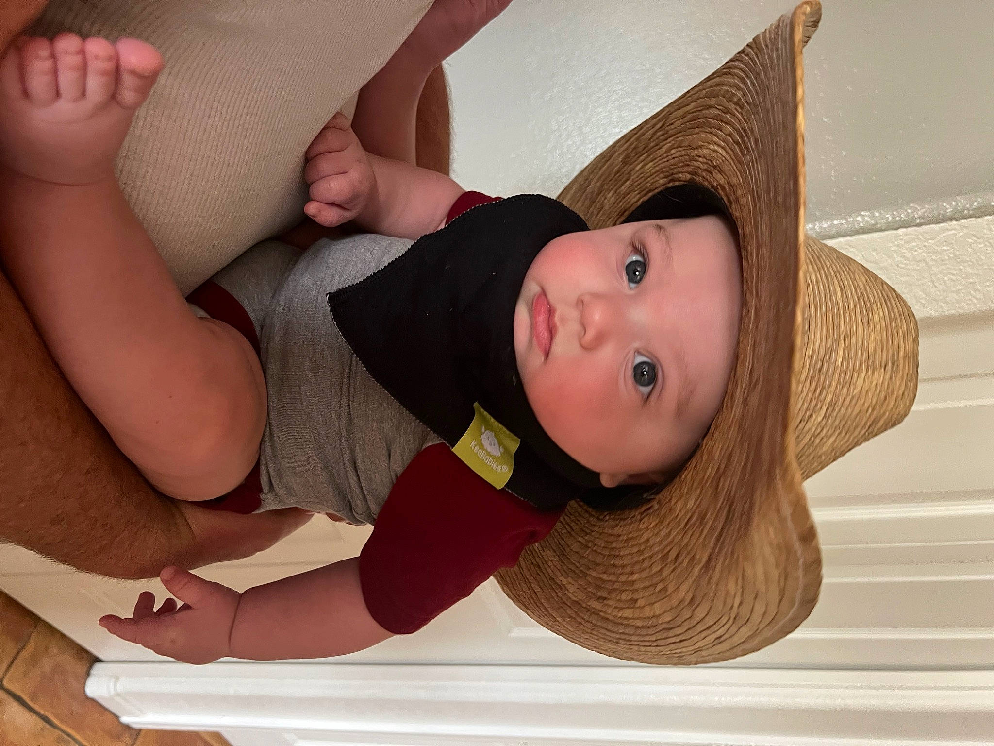 Thomas is registered to the contest to win money with this photo: arm, baby_toddler_clothing, comfort, elbow, eye, facial_expression, finger, hand, hat, head, headwear, human_body, joint, knee, neck, person, product, shoulder, skin, stomach