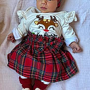 Eleanor joined the competition — help win amazing prizes! baby, infant, child, red_headband, tartan_skirt, white_shirt, heart_socks, lying_down, blanket, cute, festive_clothing, portrait, indoors, soft_light, small_hands, bright_eyes, expression, cozy, holiday_theme, adorable