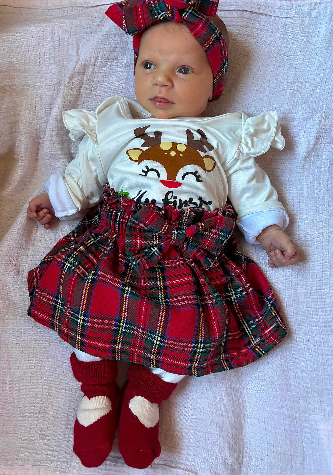 Eleanor joined the competition — help win amazing prizes! baby, infant, child, red_headband, tartan_skirt, white_shirt, heart_socks, lying_down, blanket, cute, festive_clothing, portrait, indoors, soft_light, small_hands, bright_eyes, expression, cozy, holiday_theme, adorable