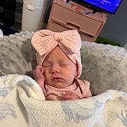 Hazleigh joined the competition — help win amazing prizes! baby, newborn, sleeping, blanket, headband, pink_bow, cozy, soft, cushion, infant, indoors, furniture, television, sleep, child, cute, resting, peaceful, portrait, person