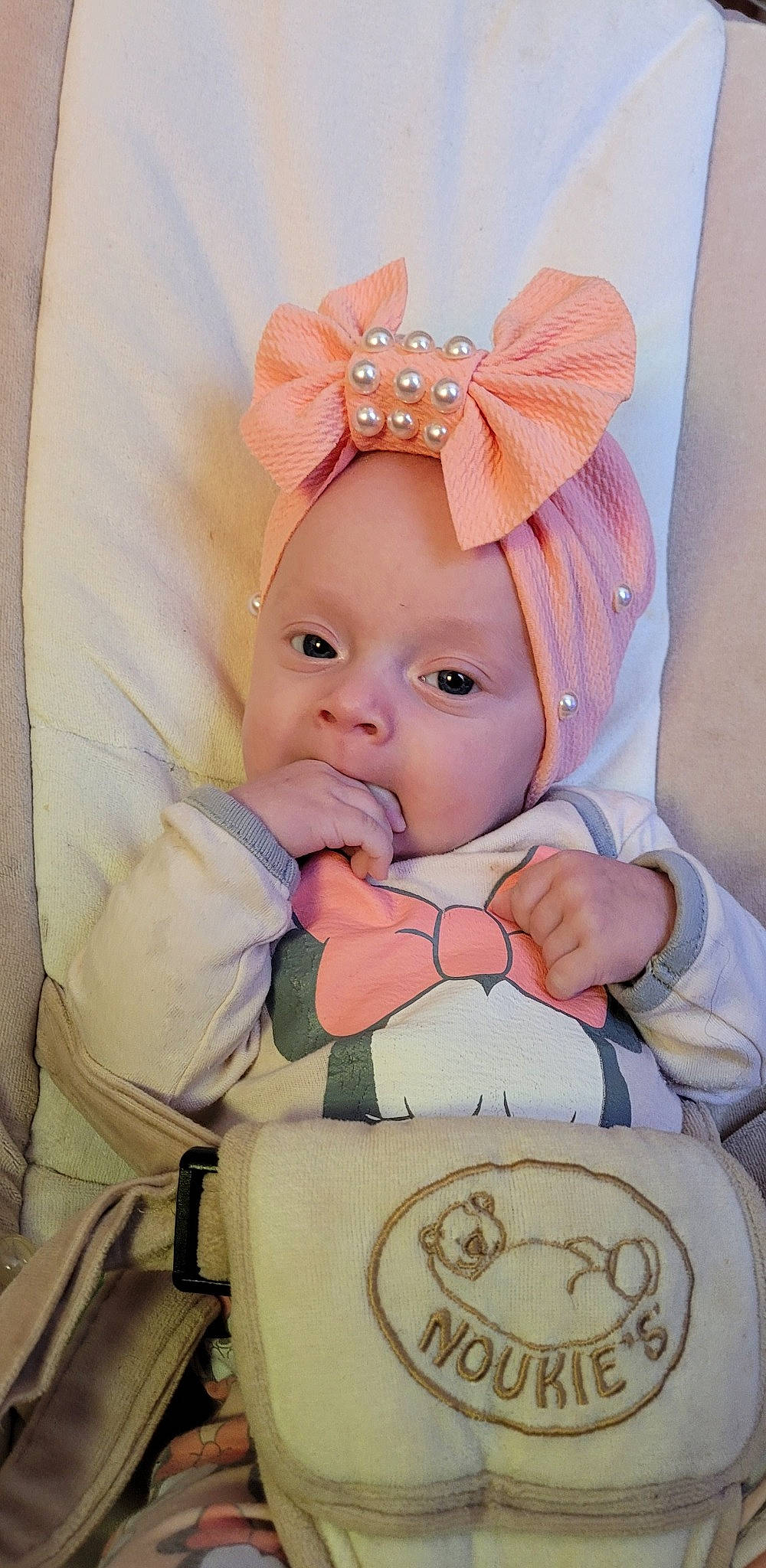 Mia participe au concours pour gagner de l'argent avec cette photo : baby, baby_safety, baby_toddler_clothing, cheek, child, chin, comfort, eye, eyebrow, eyelash, facial_expression, happy, headwear, human_body, iris, lip, person, pink, skin, sleeve