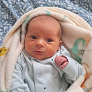 Finn joined the competition — help win amazing prizes! baby, infant, blanket, blue_onesie, face, newborn, wrapped, cute, small_hand, soft_texture, sleepwear, bedroom, young_child, portrait, lying_down, cozy, expression, skin, human, indoors