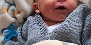Finn joined the competition — help win amazing prizes! baby, blanket, child, comfort, cozy, cute, face, indoors, infant, knitted_sweater, newborn, pacifier, peaceful, person, resting, sleeping, smiling, soft, toddler, wrapped