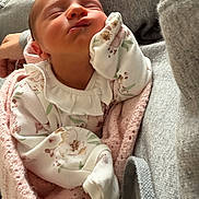 Aria is registered to the contest to win money with this photo: newborn, baby, infant, sleeping, blanket, floral_clothing, pink, white, cute, peaceful, hand, face, closeup, soft, cozy, resting, person, indoors, fabric, knitted