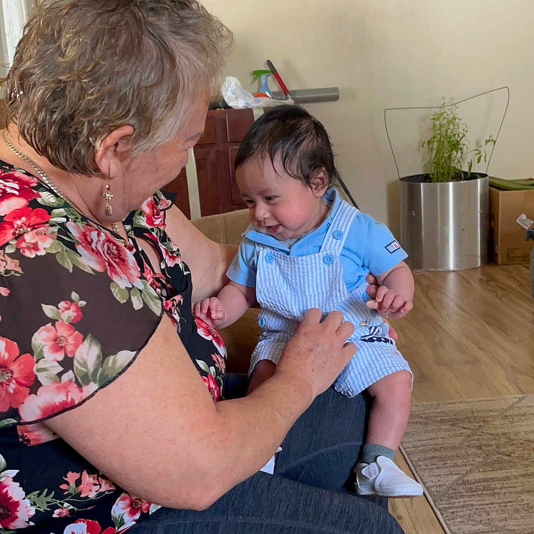 Mateo is registered to the contest to win money with this photo: architecture, baby, blouse, building, clothing, couch, face, furniture, head, indoors, interiordesign, livingroom, pants, people, person, photography, plant, portrait, pottedplant, room