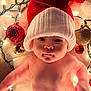 baby, infant, santa_hat, christmas_lights, ornaments, holiday, festive, cute, face, skin, expression, decorations, red, white, glowing, soft, blanket, christmas, celebration, holiday_season