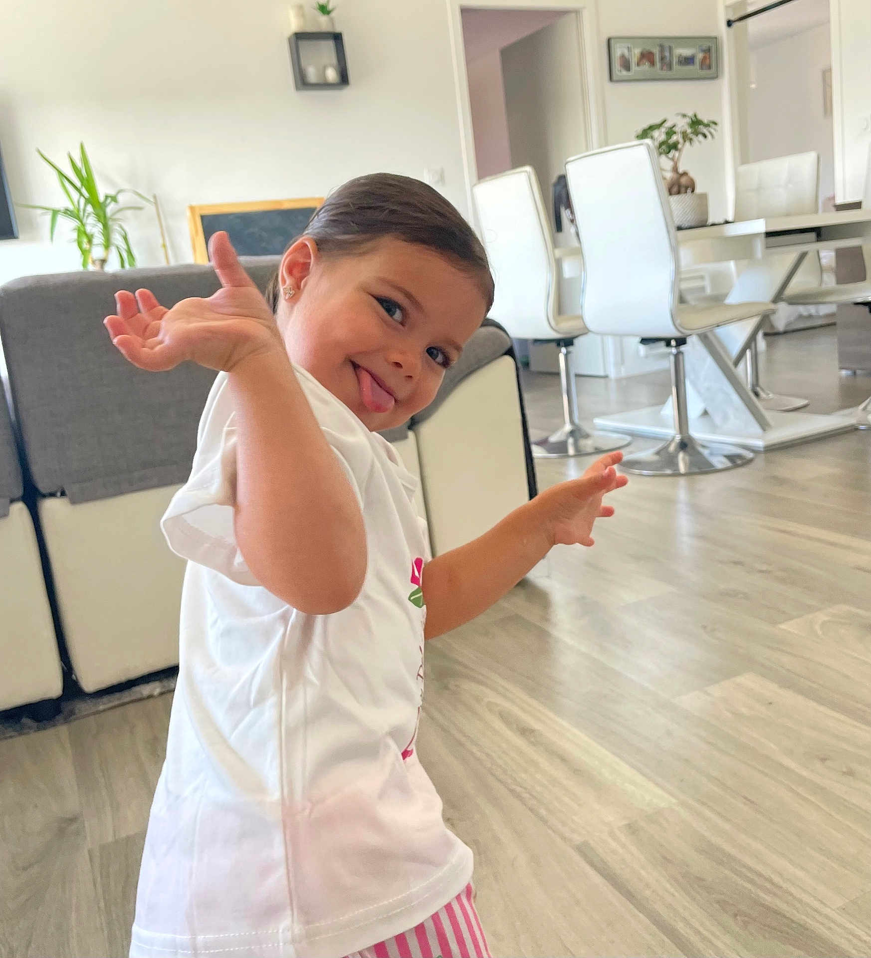 Ayem a rejoint le concours — aidez-le/la à gagner de superbes lots ! child, playful, tongue_out, white_tshirt, striped_pants, indoor, living_room, modern_furniture, wooden_floor, plant, earrings, smiling, person, home, happy, casual, cute, fun, portrait, light