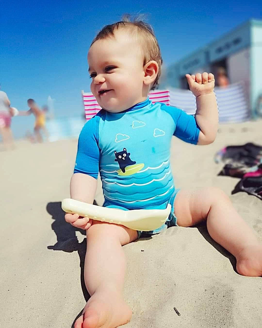 Timotë participe au concours pour gagner de l'argent avec cette photo : arm, baby, beach, beauty, blue, child, fun, hand, happy, leg, person, play, sand, sitting, skin, sky, smile, summer, thigh, toddler