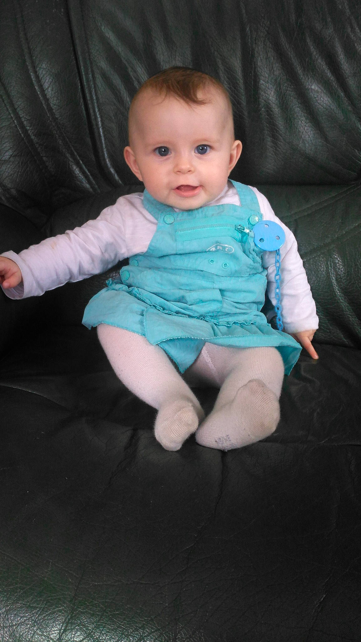 Léa participe au concours pour gagner de l'argent avec cette photo : arm, baby, baby_toddler_clothing, cheek, child, chin, comfort, couch, eye, facial_expression, flash_photography, gesture, iris, leg, person, purple, skin, sleeve, smile, t_shirt