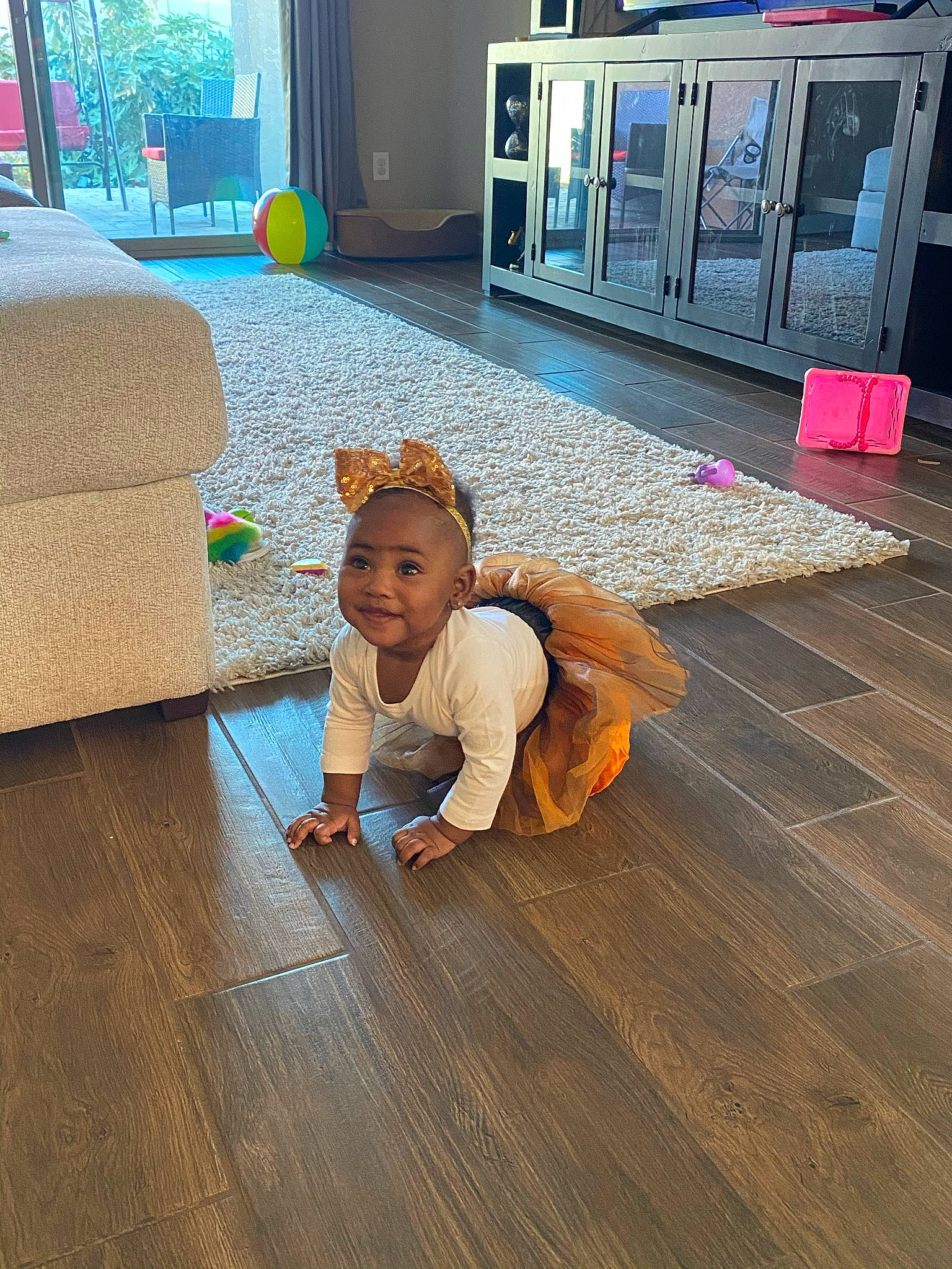 Averi is registered to the contest to win money with this photo: child, floor, flooring, fun, grass, happy, hardwood, human_leg, joy, laminate_flooring, leisure, lighting, person, sidewalk, sitting, smile, standing, toddler, varnish, wood