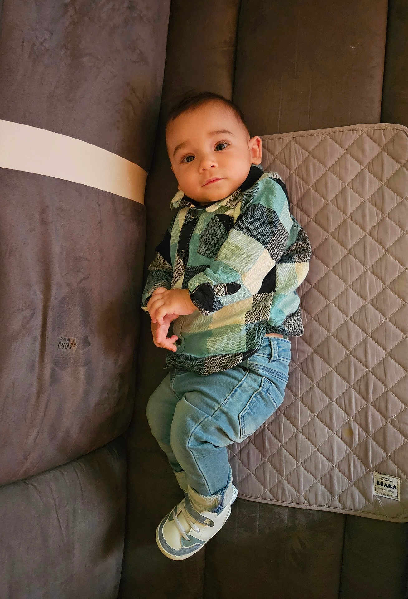 Melyan participe au concours pour gagner de l'argent avec cette photo : baby, child, plaid_shirt, denim_jeans, sneakers, couch, quilted_mat, indoor, portrait, casual_clothing, relaxed, curious, infant, home, fabric, seated, soft_lighting, comfortable, cute, young