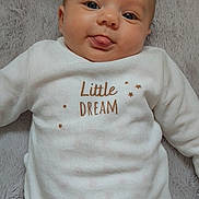 Luciana a rejoint le concours — aidez-le/la à gagner de superbes lots ! baby, infant, face, tongue, white_clothing, blanket, soft_texture, lying_down, cute, playful, smiling, child, portrait, indoors, cozy, close_up, skin, eyes, head, expression