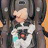 Aubrey joined the competition — help win amazing prizes! baby, infant, sleeping, car_seat, safety_harness, hat, bow, pacifier, white_clothing, onesie, portrait, indoors, transportation, child, seated, close_up, safety, gray, orange_background, photograph