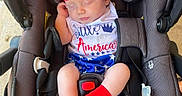 Aubrey is registered to the contest to win money with this photo: baby, infant, sleeping, car_seat, red_bow, red_socks, patriotic_outfit, blue_clothing, stars, white_clothing, portrait, close_up, indoors, adult_hand, safety_harness, headband, peaceful, nap, child, face