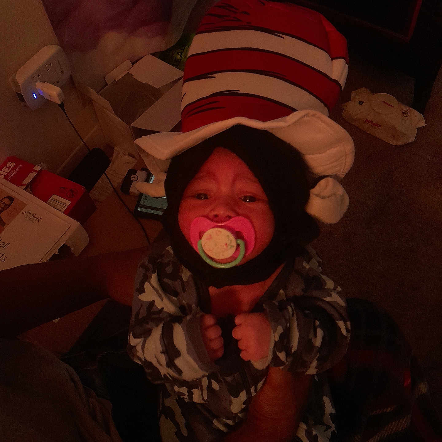 Winter joined the competition — help win amazing prizes! adult, baby, blanket, box, camouflage_clothing, carpet, child, dim_lighting, furniture, hands, hat, holding, indoor, infant, pacifier, person, power_outlet, room, striped_hat, toy