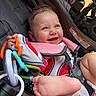 Evelyn is registered to the contest to win money with this photo: baby, baby_gear, bare_feet, blue_eyes, child, close_up, colorful, face, happy, infant, infant_clothing, outdoor, playful, portrait, seated, smiling, stroller, sunlight, teether, toy