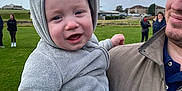 Nate joined the competition — help win amazing prizes! baby, child, man, outdoor, grass, cloudy_sky, hoodie, blanket, smile, people, casual_clothing, portrait, holding, cute, warm_clothing, park, family, happy, infant, headwear