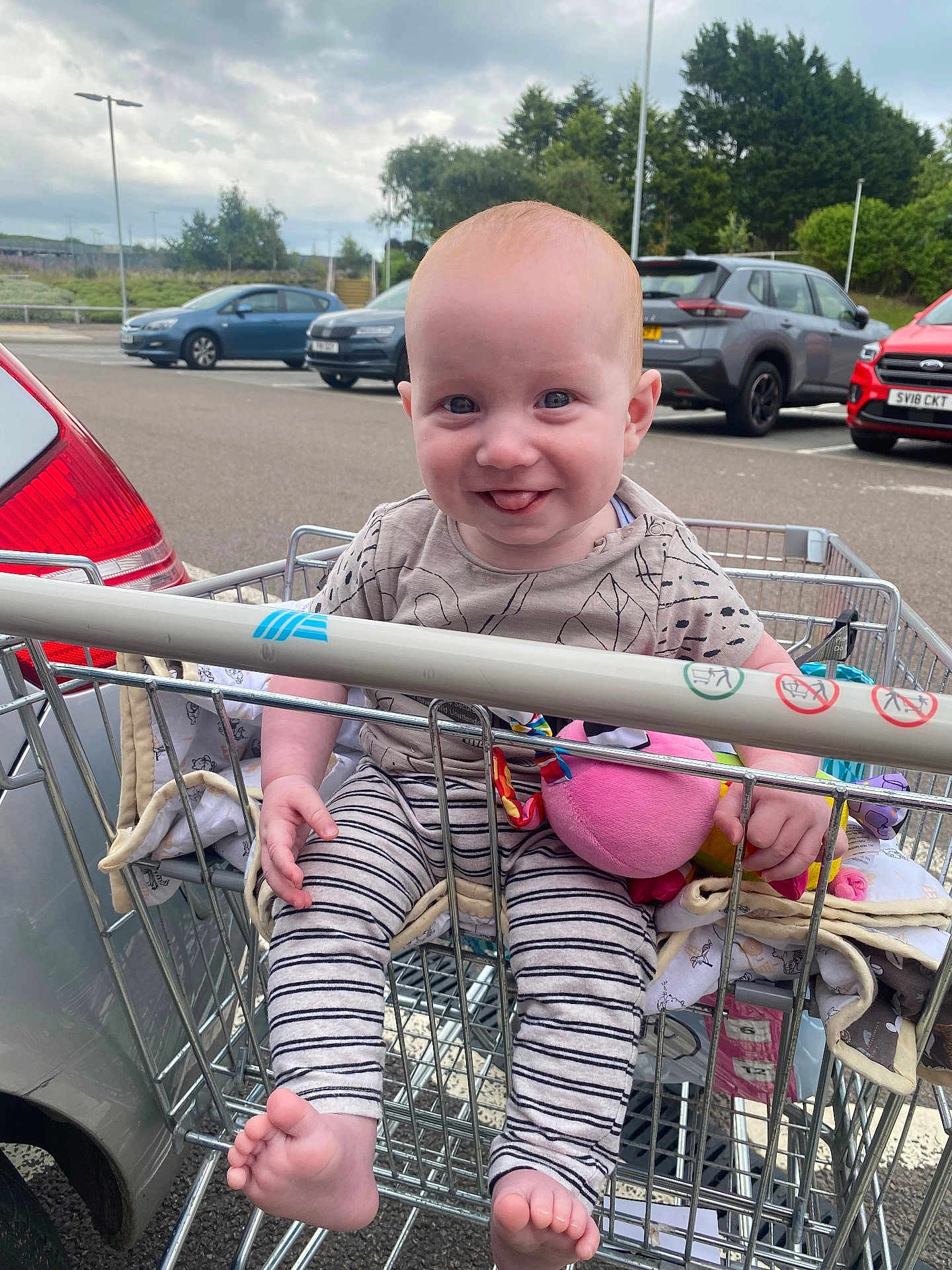 Nate joined the competition — help win amazing prizes! baby, barefoot, cars, child, clothing, cloudy_sky, cute, expression, happy, infant, metal, outdoor, parking_lot, person, playful, seat, shopping_cart, smiling, striped_pants, toy