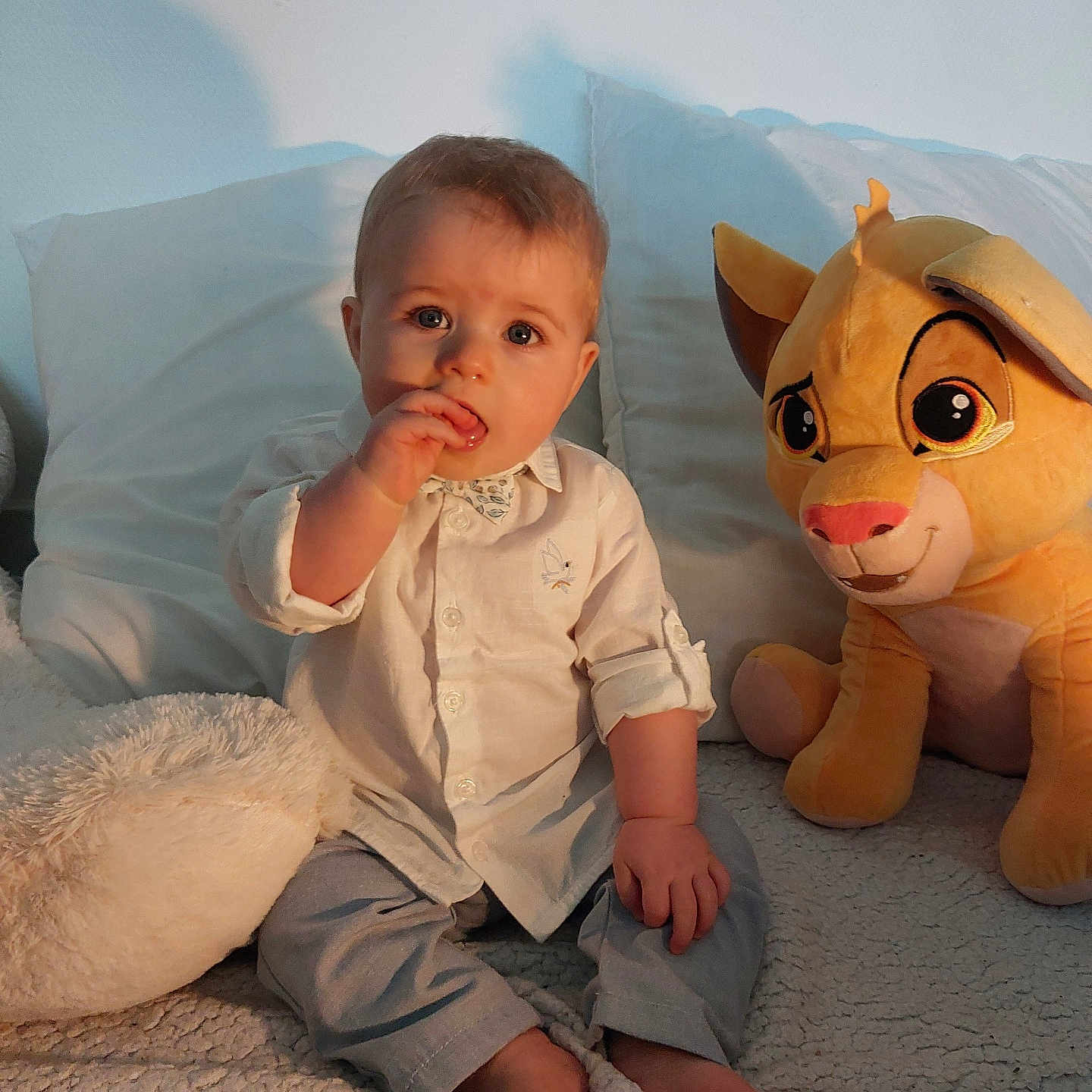 Hélios Hy a rejoint le concours — aidez-le/la à gagner de superbes lots ! baby, barefoot, blanket, child, cozy, curious, cute, face, foot, hand, indoor, light, lion_king, pants, pillow, plush_toy, shirt, simba, sitting, soft_toy