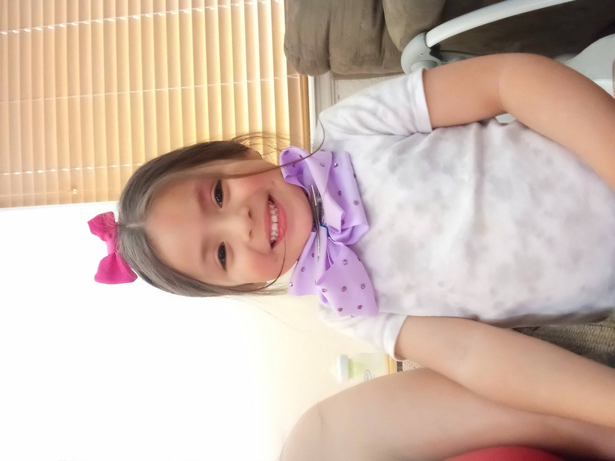 Genesis is registered to the contest to win money with this photo: baby, baby_toddler_clothing, cheek, child, comfort, dress, fun, happy, human_leg, joy, knee, magenta, person, room, sitting, skin, smile, thigh, thumb, toddler